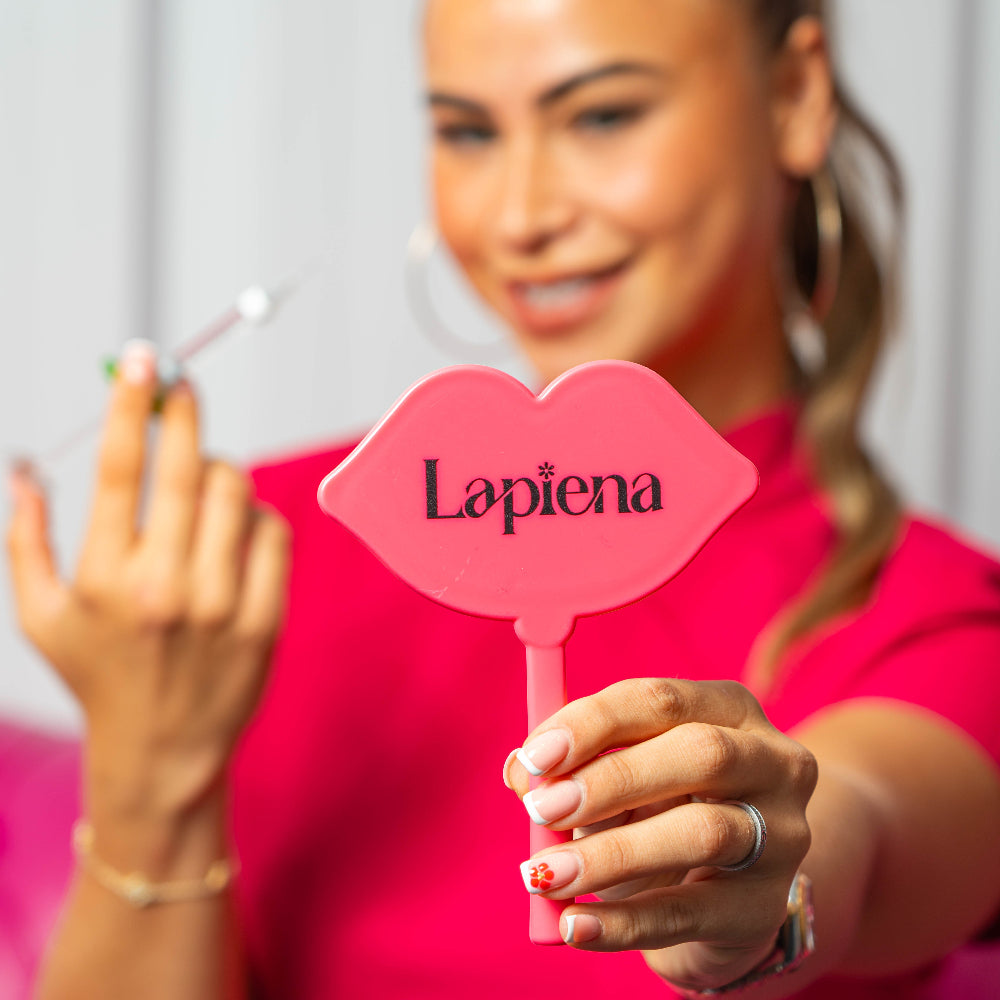 Lapiena pink mirror held by an ambassador also holding a syringe of lapiena