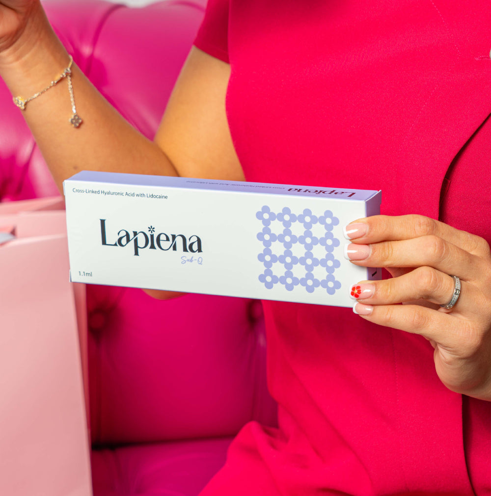 Person holding a box of Lapiena Sub-q against a pink background