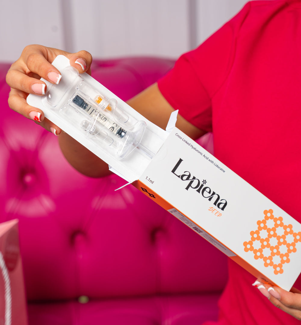 Person holding a box of Lapiena deep syringes against a pink background