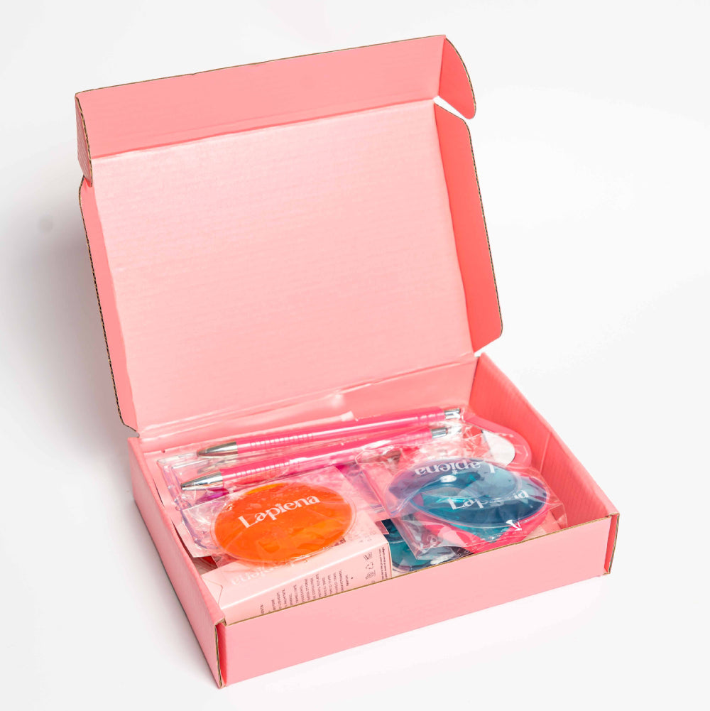 Pink box containing lapiena branded eye masks, pen, lip gloss on white background