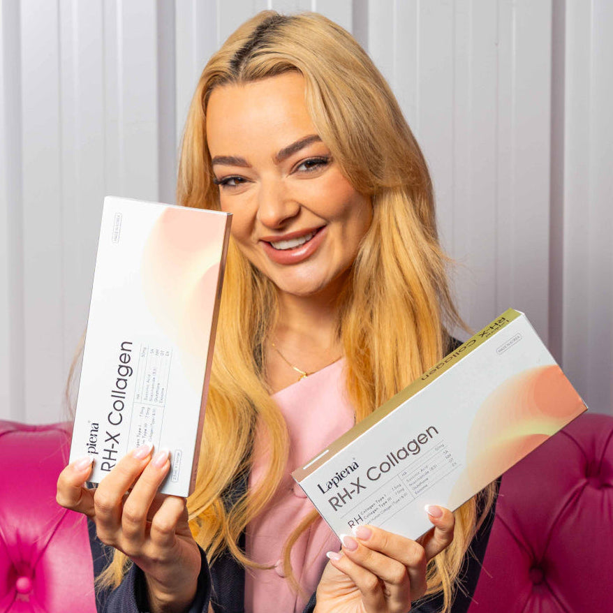 Woman holding two boxes of RH-X Collagen Booster in front of a pink couch.