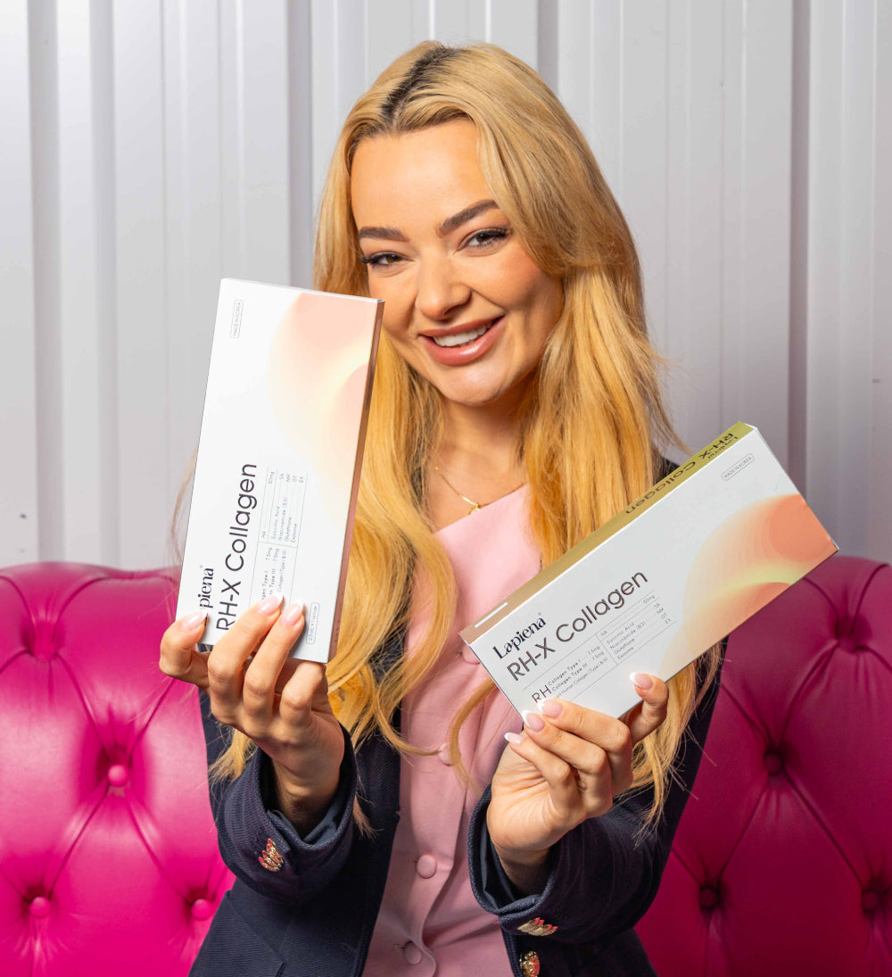 Woman holding two boxes of RH-X Collagen Booster in front of a pink couch.