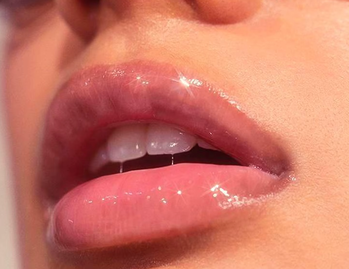 Close-up of glossy lips with a neutral background